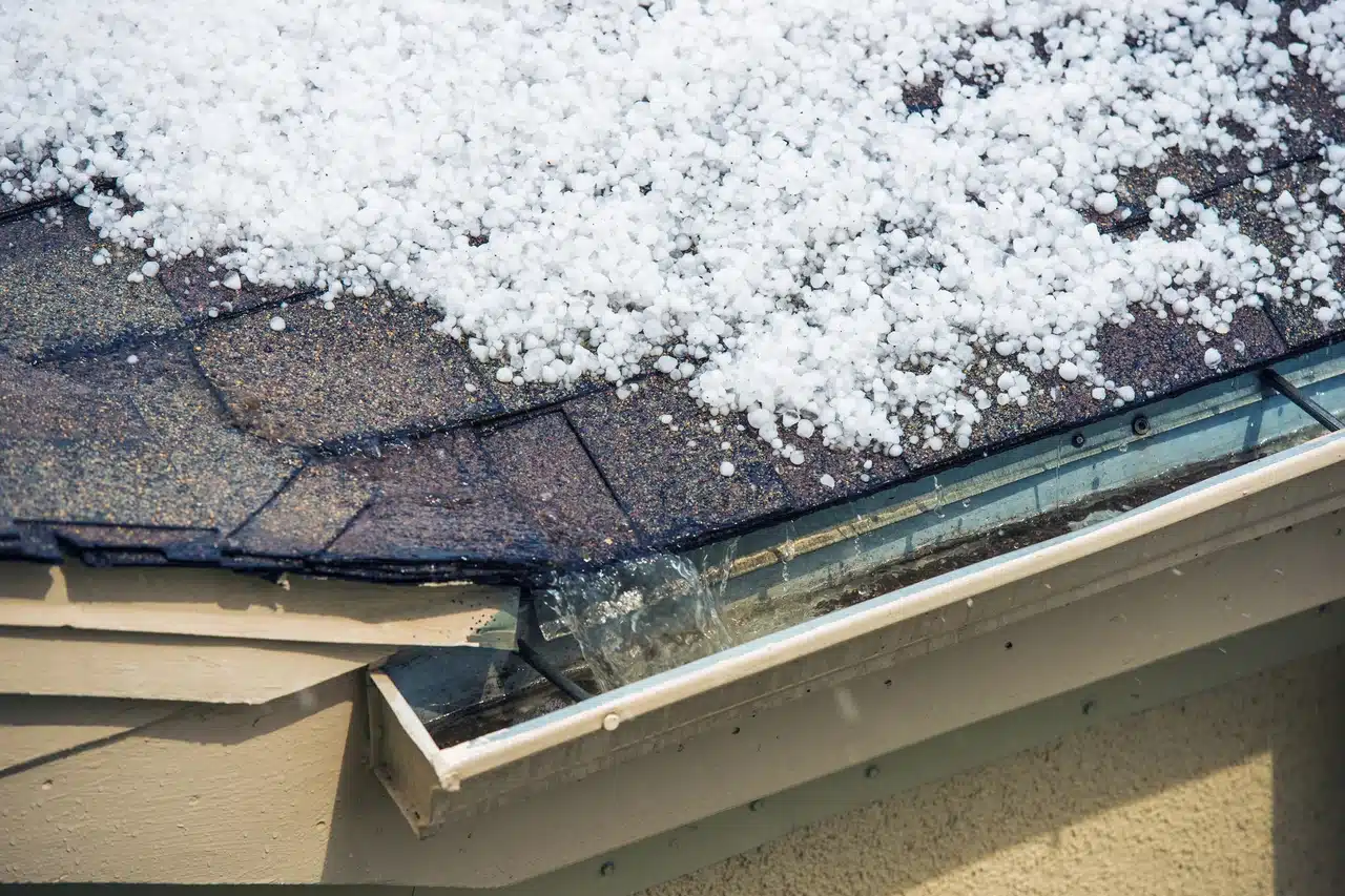 Hailstones on roof and overflowing gutter.