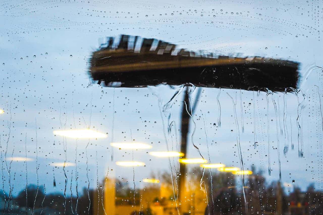 Rain-soaked window cleaned with a brush - Everything You Need to Know About Water-Fed Pole Systems