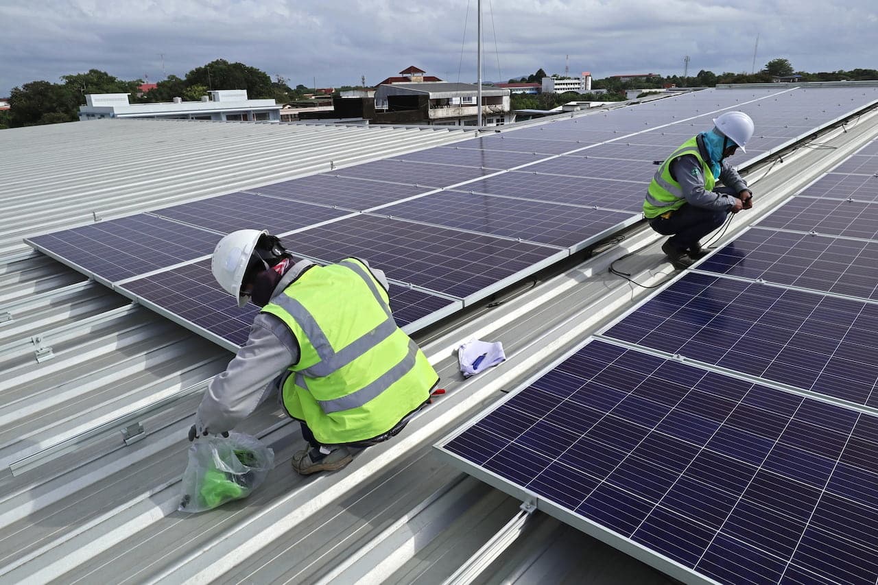 Get Your Solar Panels Cleaned After These Types of Weather Workers installing solar panels on rooftop