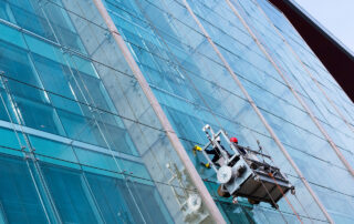 A pro cleans high-rise glass—The Top 5 Challenges of Commercial Window Cleaning revealed by Ease Your Panes, where safety meets sparkling results.