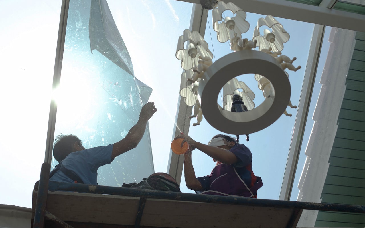 What Can I Use to Clean My Tinted Windows Inside Workers cleaning large glass skylight indoors